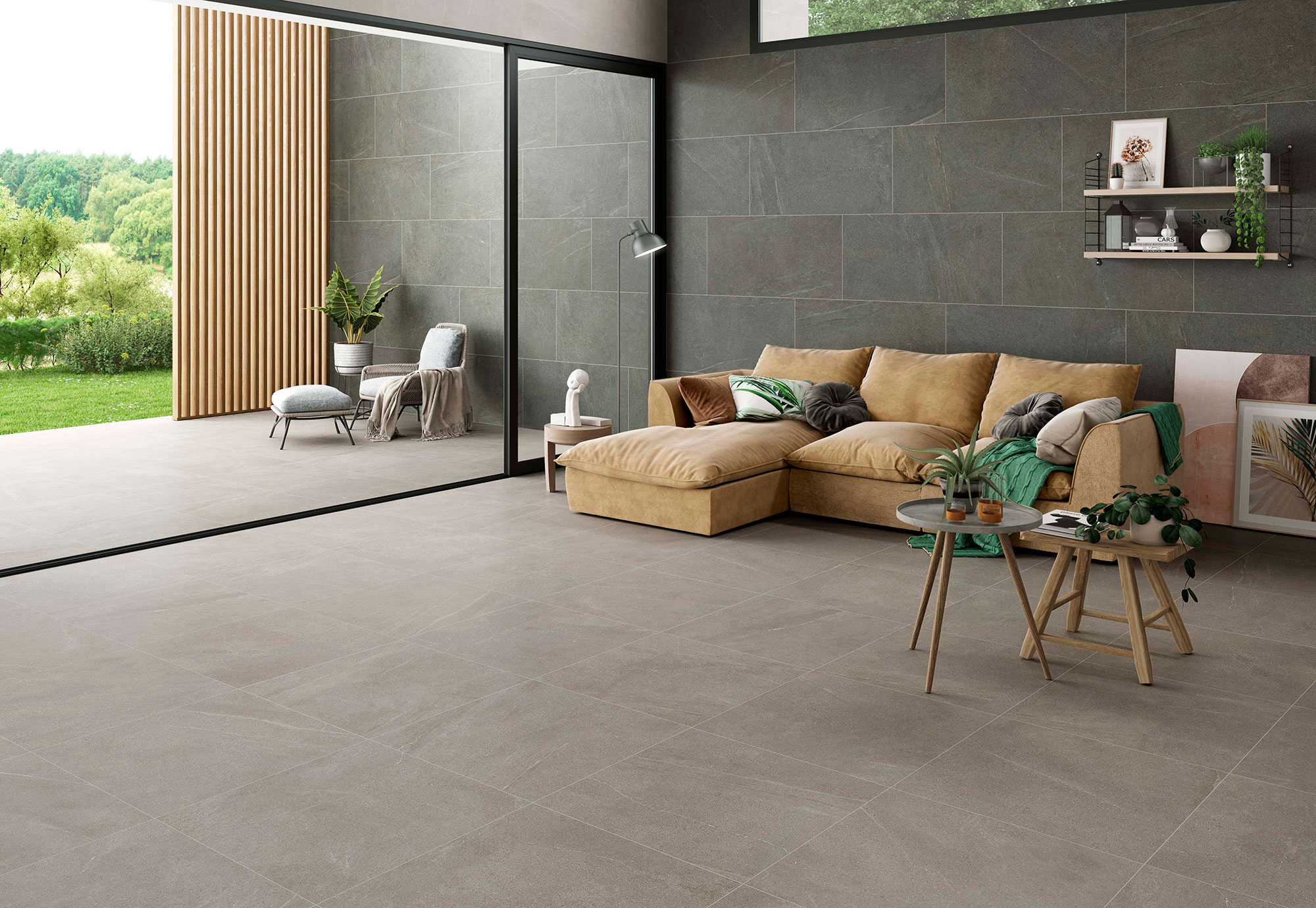 STN-AMB-BELLEVUE-INOUT-GRAPHITE-GREY-60X120+GREY-75X75 Salón con pavimento y revestimiento cerámico gris efecto piedra, sofá beige y terraza ajardinada