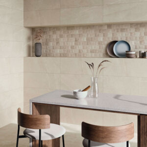 STN-AMB-BELLEVUE-IVORY-33,3x90 Showroom de azulejos: pared beige con friso texturado, encimera y taburetes