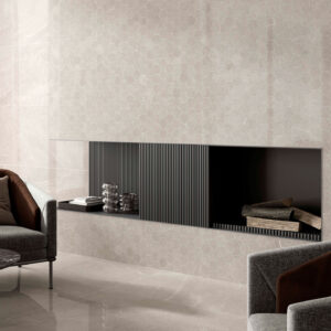STN-AMB-BELLEVUE-MALLA-GREY-PULIDO Sala moderna con revestimiento cerámico hexagonal beige, chimenea empotrada y butacas.