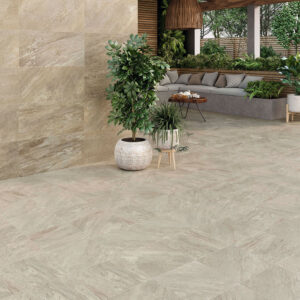STN-AMB-ICARIA-OCRE-37X75+-ICARIA-BEIGE-33X33 Porche con pavimento y revestimiento cerámico efecto piedra, sofá y plantas