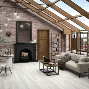 Salón con pavimento cerámico efecto madera, pared de ladrillo visto, sofá y grandes ventanales