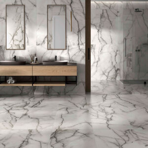 Baño moderno con pavimento y revestimiento cerámico efecto mármol, doble lavabo y ducha.