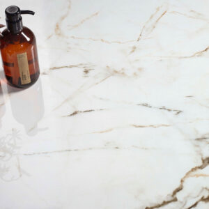 Encimera cerámica efecto mármol blanco con vetas marrones y frascos de vidrio ámbar