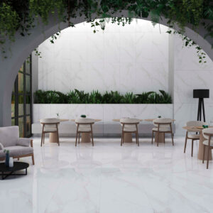 Showroom con azulejos efecto mármol en suelo y pared, sillas y vegetación.