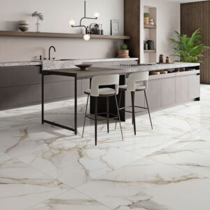 Showroom de cocina con isla y pavimento cerámico efecto mármol blanco y vetas doradas.