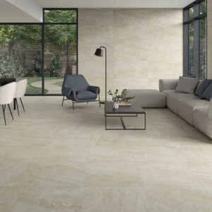 Sala de exposición con pavimento y revestimiento cerámico beige, sofá y ventanales al jardín