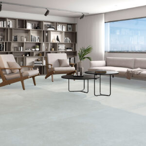 Tienda con suelo cerámico claro en losas grandes, sofá, butacas de madera y estantería.