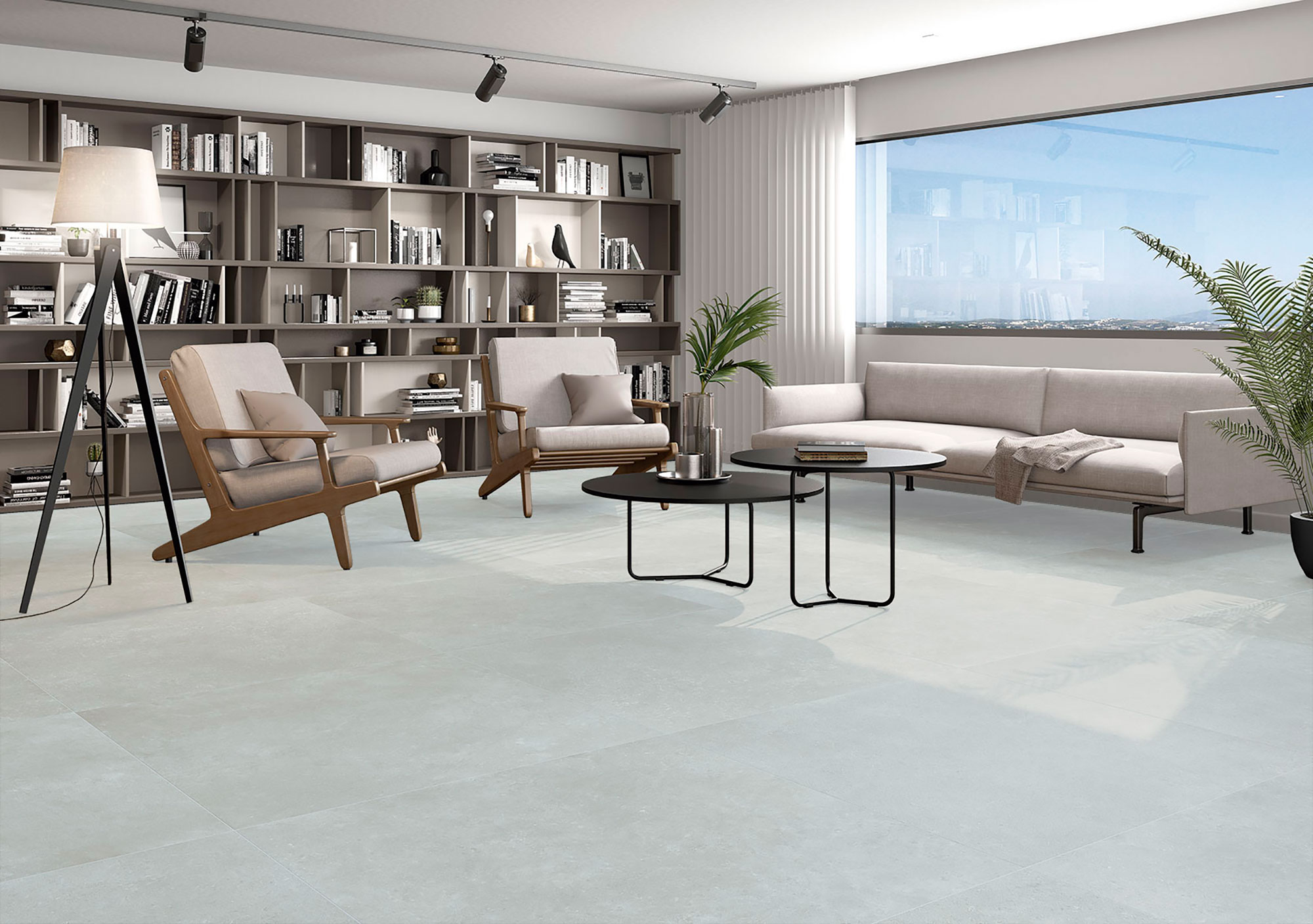 Tienda con suelo cerámico claro en losas grandes, sofá, butacas de madera y estantería.