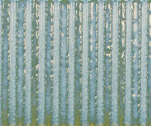 Azulejo cerámico acanalado en azul verdoso con acabado brillante y textura