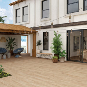 Amplia terraza con suelo de madera clara, pérgola de madera con dos sillones acolchados azules y varias macetas con plantas.