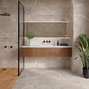 Baño expositor con grandes azulejos efecto mármol, mueble flotante de madera y ducha