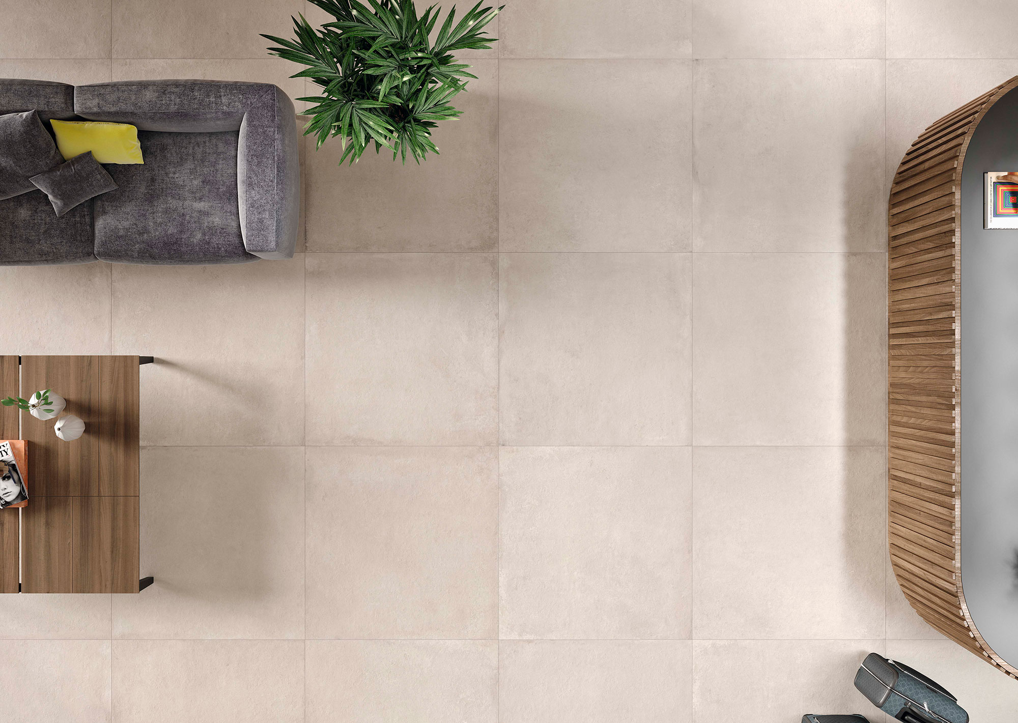 Salón visto desde arriba con pavimento cerámico beige, sofá gris, mesa de madera y planta.