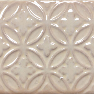 Azulejo cerámico beige brillante con relieve geométrico de círculos entrelazados