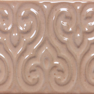 Azulejo cerámico beige brillante con relieve ornamental de volutas repetidas
