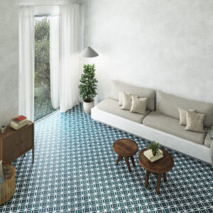 Salón luminoso con suelo cerámico azul de motivos geométricos, sofá y mesas de madera.