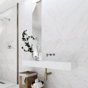 AMB-01-CALACATTA-GOLD-30X90-(3) Baño con azulejos efecto mármol y relieve ondulado, ducha a la izquierda y lavabo flotante.
