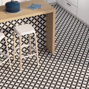 Cocina con pavimento y frontal cerámico geométrico blanco y negro y barra de madera con taburetes