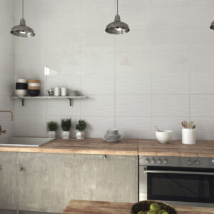 Cocina mostrador con azulejos cerámicos ondulados blancos, encimera madera y lámparas metálicas