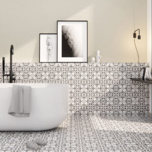 Exposición baño: bañera exenta sobre pavimento y zócalo con azulejos cerámicos geométricos