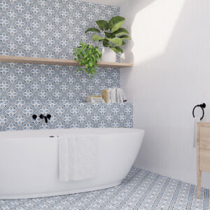 Baño con bañera exenta y azulejos cerámicos geométricos azul y blanco en suelo y pared.