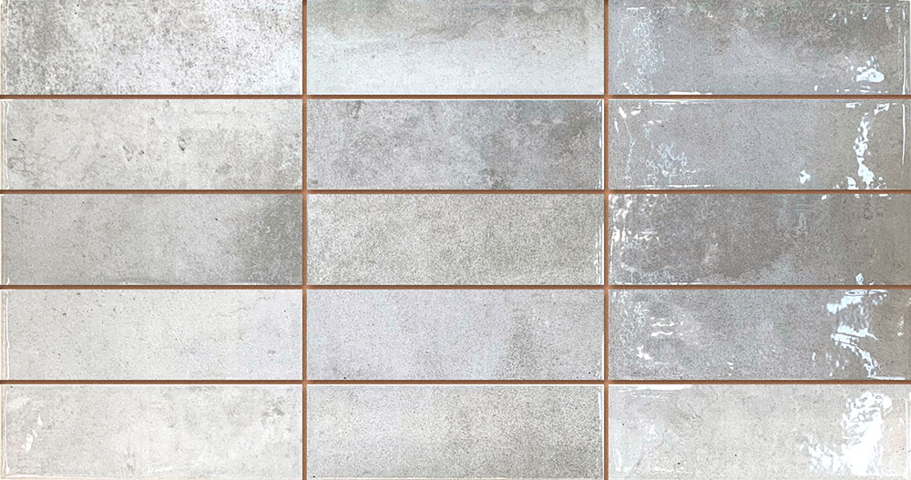 Azulejos cerámicos rectangulares grises con texturas mate y brillo, juntas marrón claro