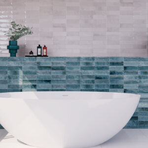 Baño con bañera blanca, grifo cromado y revestimiento cerámico azul y gris