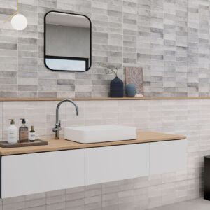 Lavabo sobre mueble flotante con encimera de madera, azulejos cerámicos gris y blanco