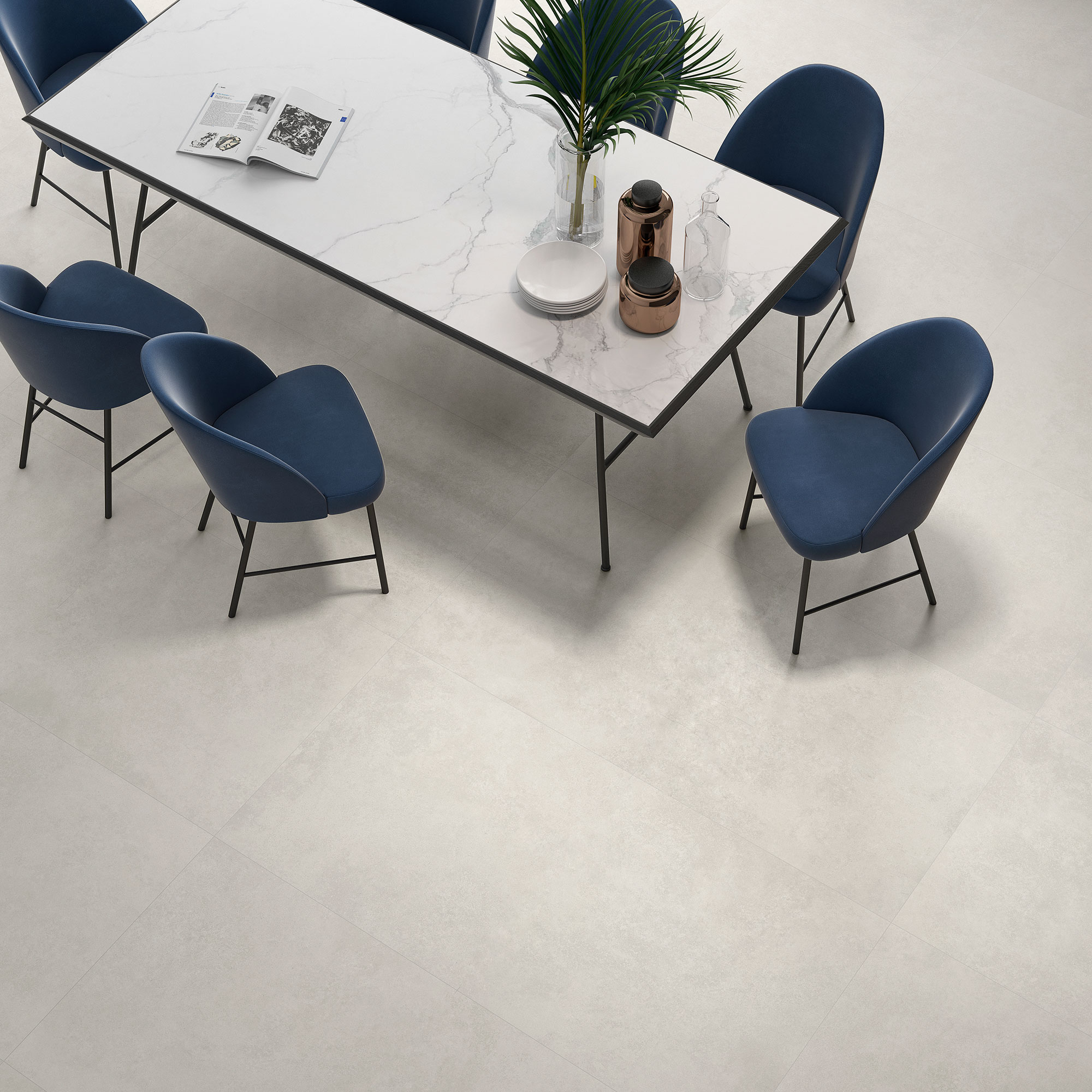 Mesa con tablero efecto mármol y sillas azules sobre pavimento cerámico beige