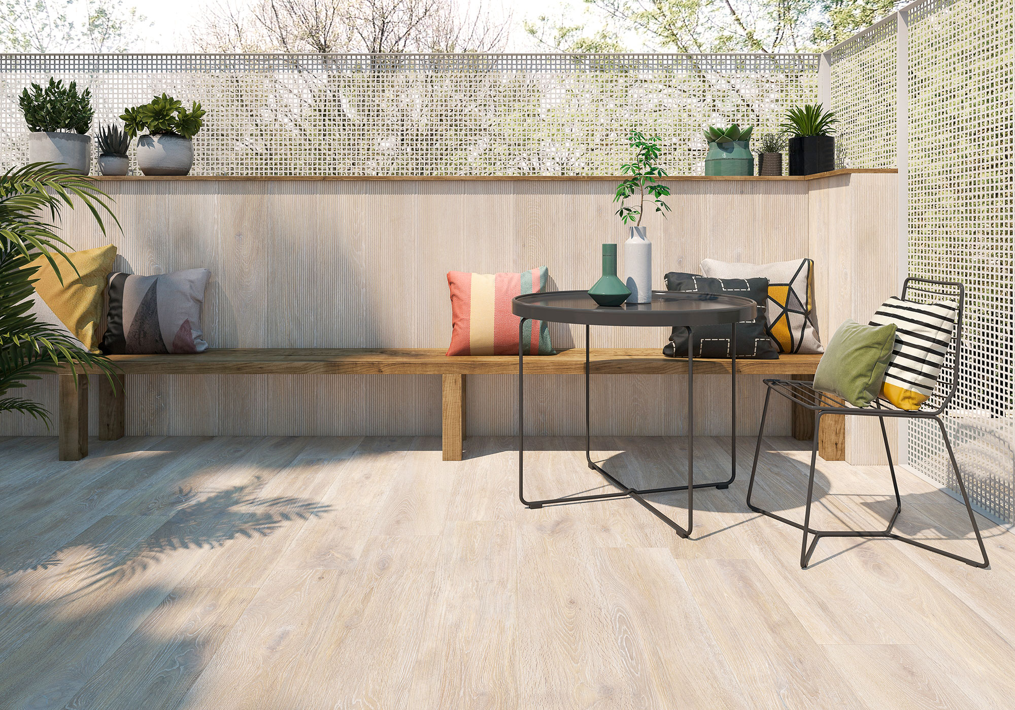 Terraza showroom con suelo cerámico efecto madera, banco, mesa redonda y cojines.