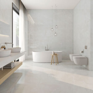 Baño de exposición con bañera exenta, doble lavabo, ducha y revestimiento cerámico jaspeado