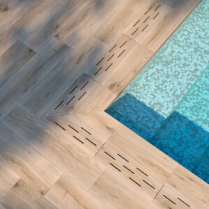 Piscina con escalones de mosaico azul y pavimento cerámico imitación madera con ranuras de drenaje