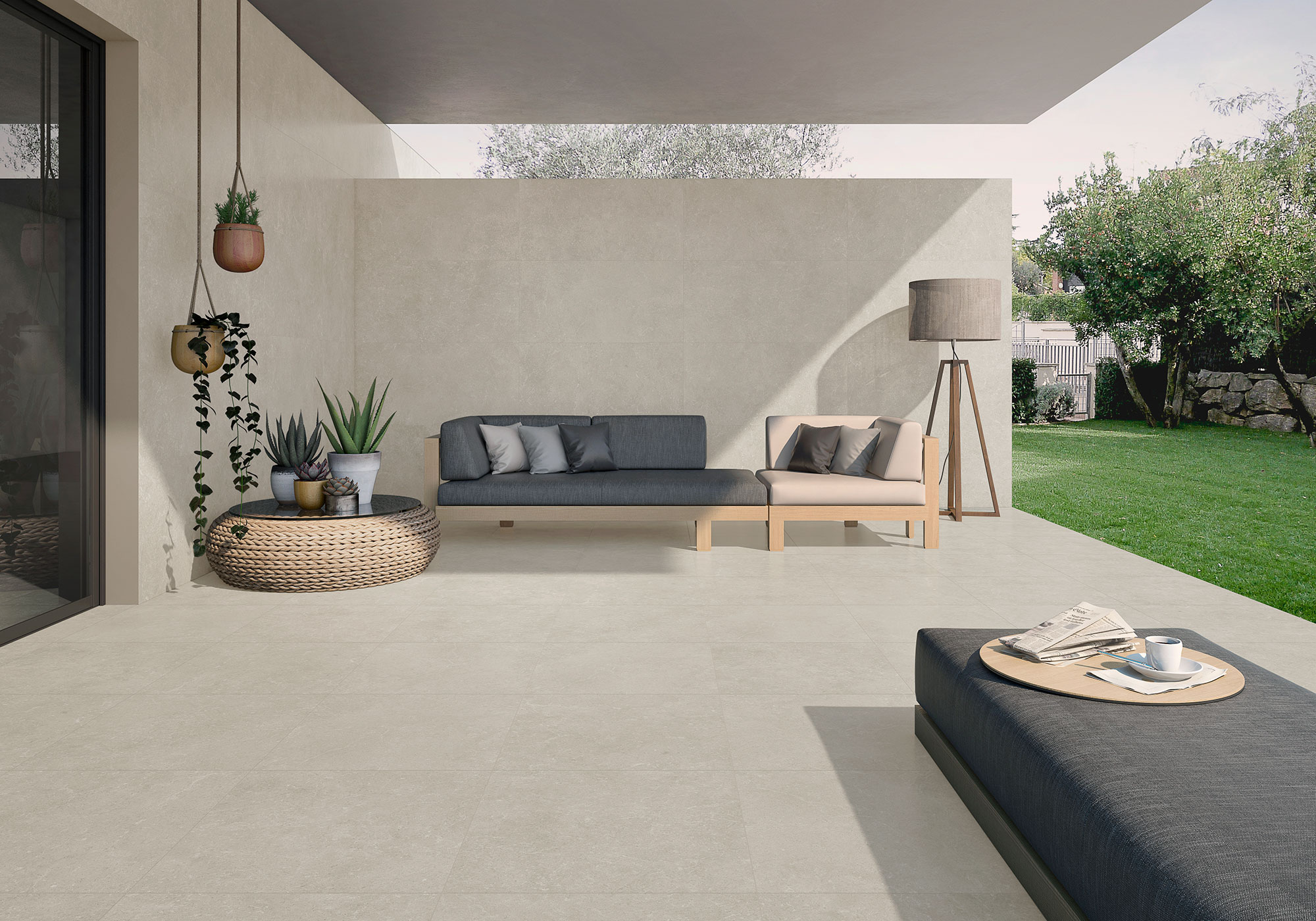 Terraza con pavimento cerámico beige, sofá modular, plantas y jardín