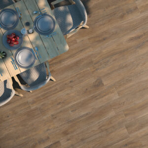 Mesa de comedor con vajilla y sillas sobre pavimento cerámico imitación madera