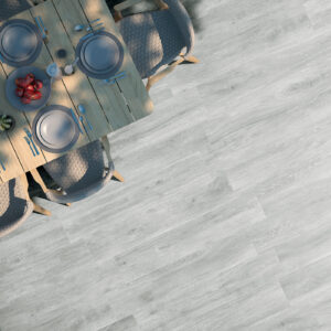 Suelo cerámico efecto madera gris claro junto a mesa puesta y sillas