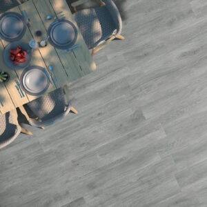 Mesa de comedor con servicio sobre suelo porcelánico gris efecto madera visto desde arriba