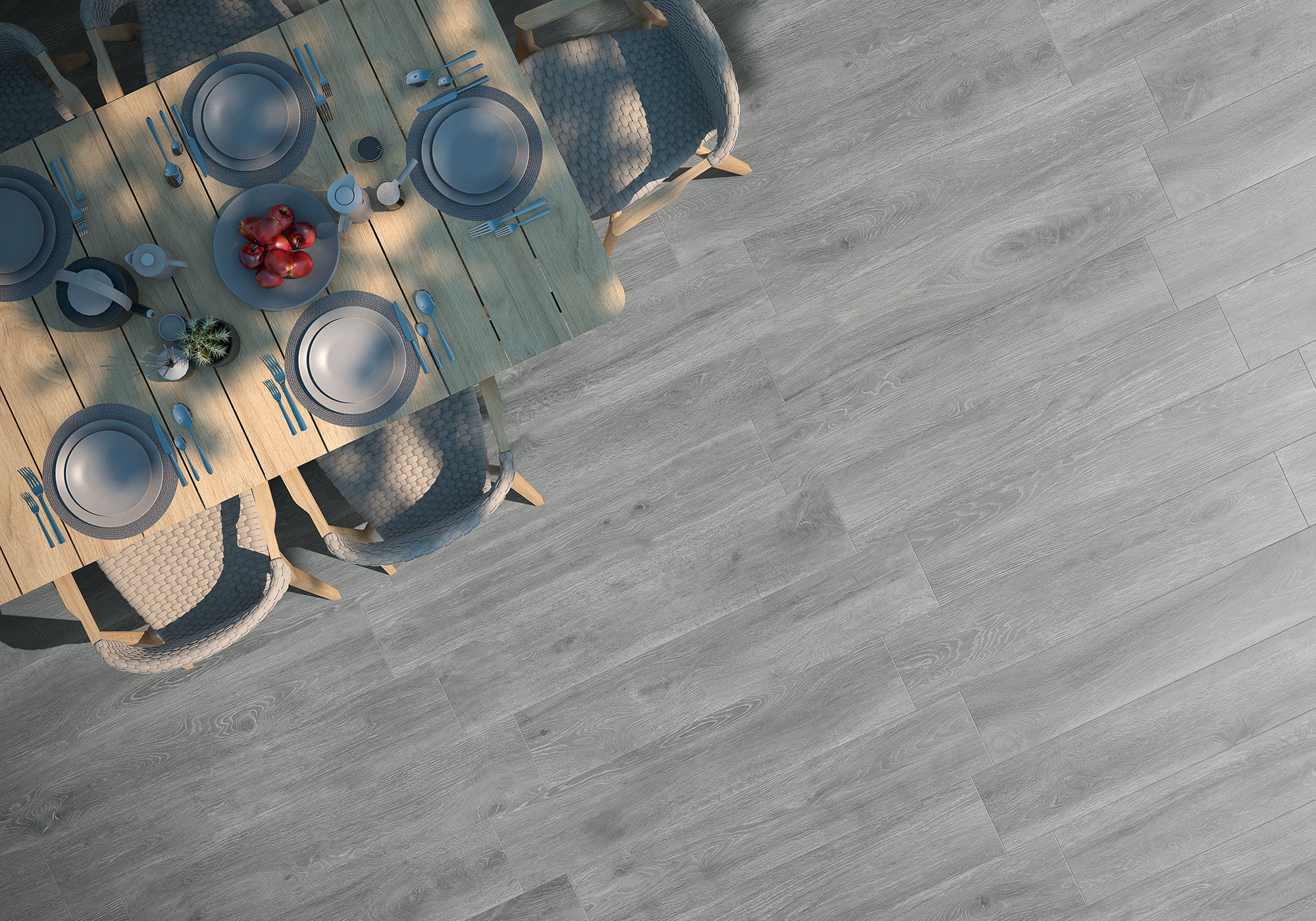 Mesa de comedor con servicio sobre suelo porcelánico gris efecto madera visto desde arriba