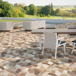 Terraza con pavimento cerámico efecto piedra en tonos beige y mobiliario exterior blanco