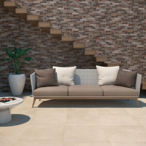 Sala con pavimento cerámico claro, revestimiento de pared tipo ladrillo, sofá y escalera flotante