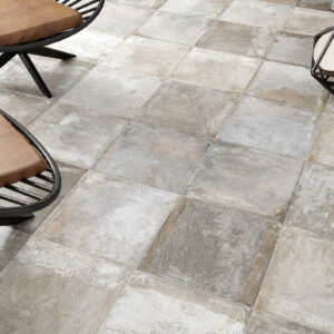 1810_ALAPLANA_Harad-Grey-45x45_rgb Azulejos cerámicos cuadrados efecto hormigón con sillas de cuero y lámpara geométrica.