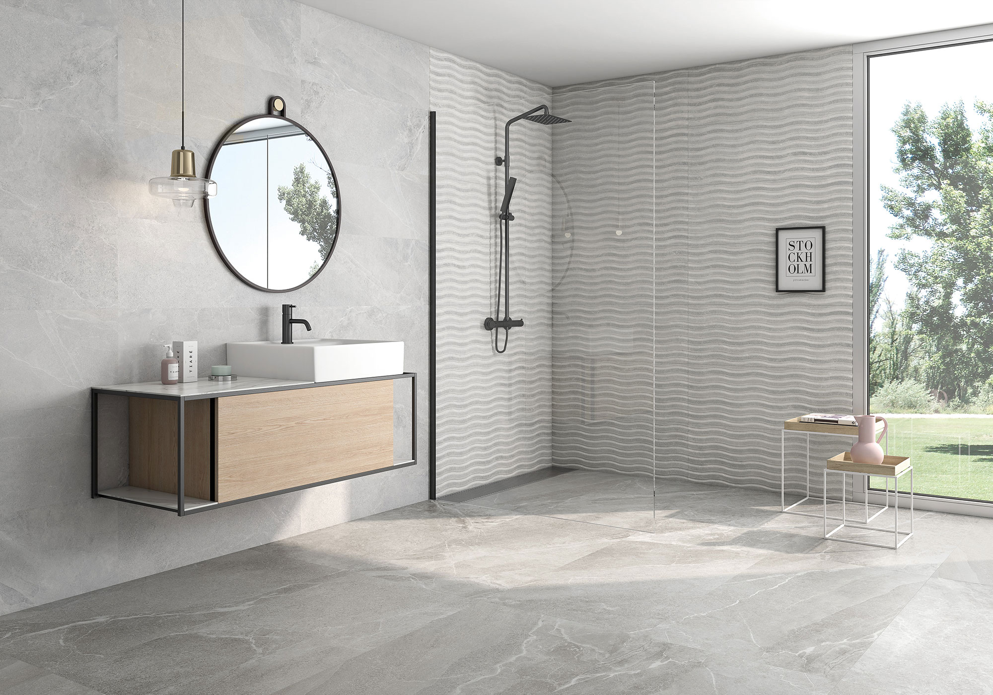 Baño moderno con pavimento y revestimiento cerámico gris, mueble flotante, espejo redondo y ducha.