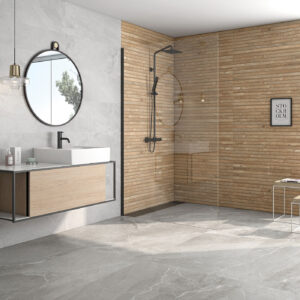 Baño expositor con pavimento gres gris, revestimiento madera en ducha y mueble lavabo flotante