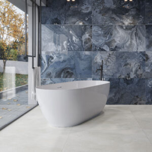 3692_ALAPLANA_URANO-BLUE+ROHE-SNOW_HQ Baño con bañera exenta, azulejo cerámico mural azul marmoleado y pavimento claro.