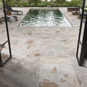 Terraza con piscina y pavimento cerámico efecto piedra en tonos beige