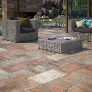 ALAPLANA_AMB.-HARAD-COTTO-30x60_RGB Terraza con pavimento cerámico envejecido en tonos tierra y muebles de ratán