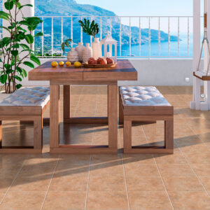 Terraza con pavimento cerámico beige, mesa y bancos de madera frente al mar