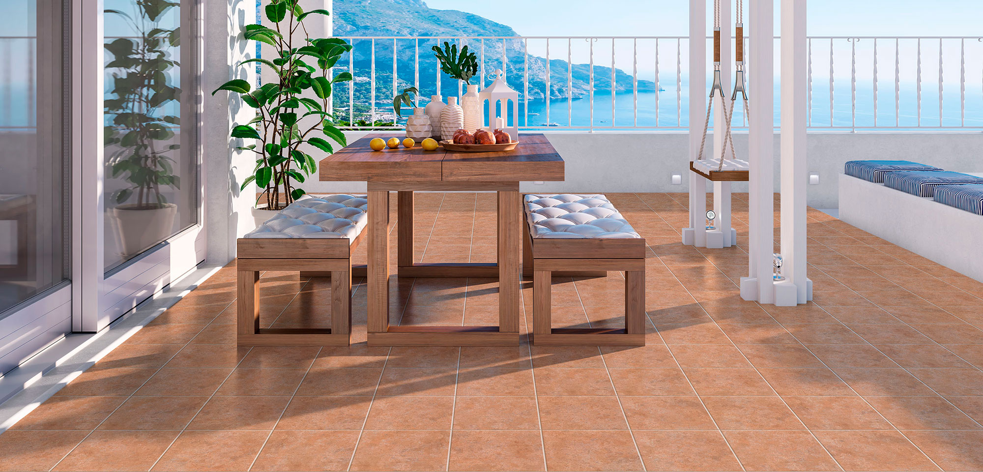 Terraza con pavimento cerámico terracota, mesa de madera, bancos acolchados y vistas al mar