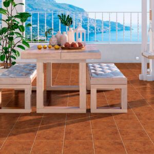 Terraza con mesa y bancos sobre pavimento cerámico marrón