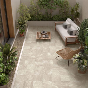 Terraza interior con pavimento cerámico efecto mármol, sofá, butaca y plantas