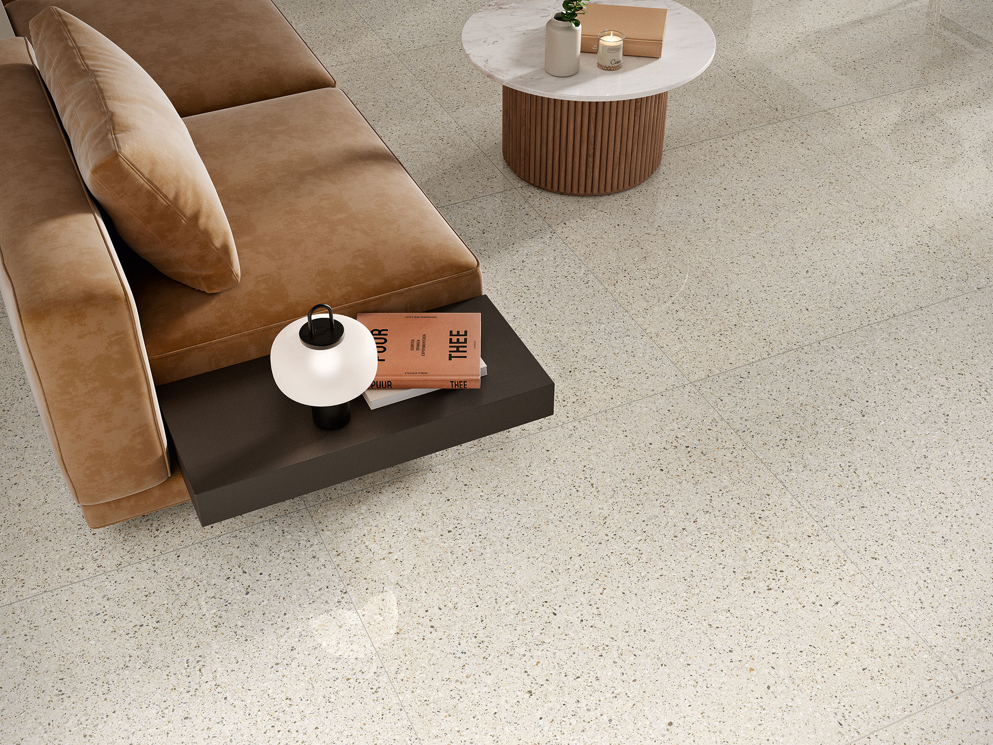 Salón con sofá marrón sobre pavimento cerámico jaspeado beige, mesa redonda y lámpara.