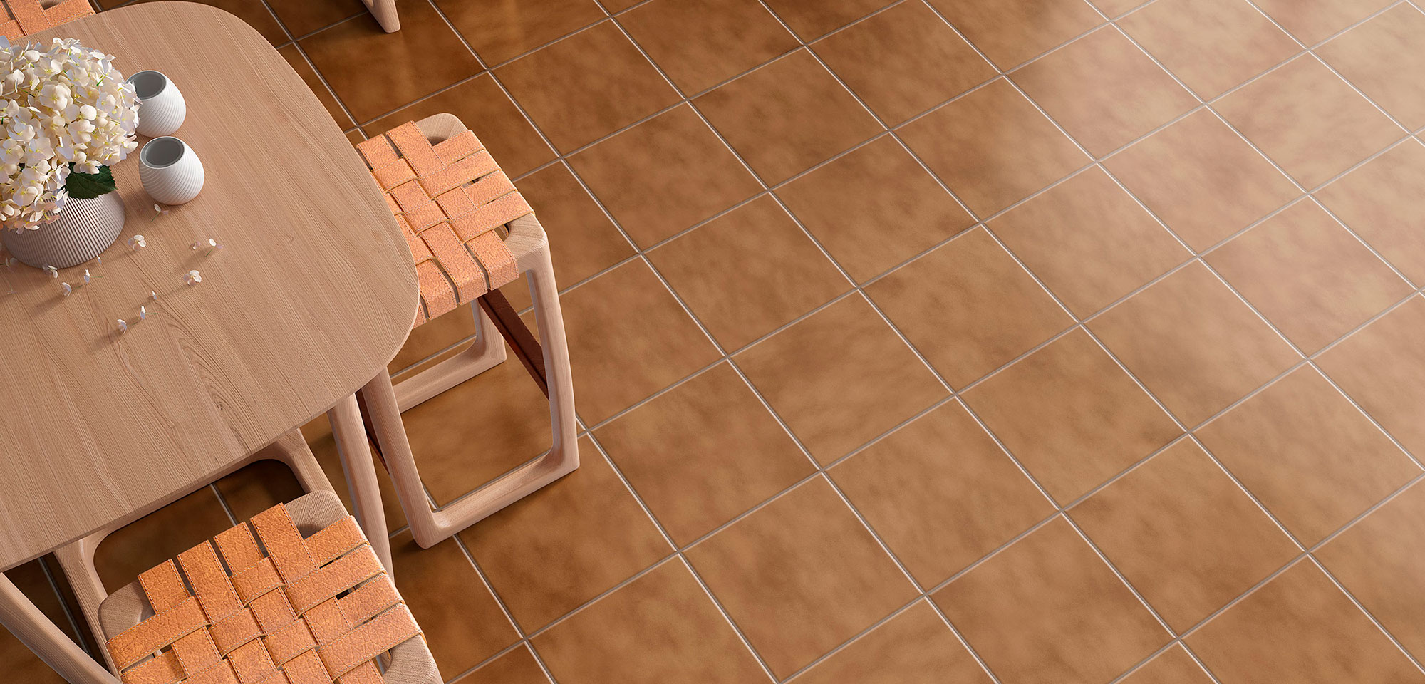 Suelo cerámico terracota, mesa de madera y taburetes con asiento trenzado y flores